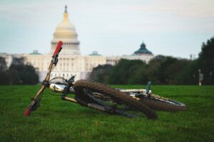 A bicycle lying on the lush green lawn with the US Capitol building in the background in Washington, DC.